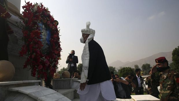 Afghan President Ashraf Ghani looks lays a wreath next to the Independence Minaret monument during the Independence Day celebrations at the Defense Ministry in Kabul, Afghanistan, Tuesday, Aug. 18, 2020. (AP Photo/Rahmat Gul)
