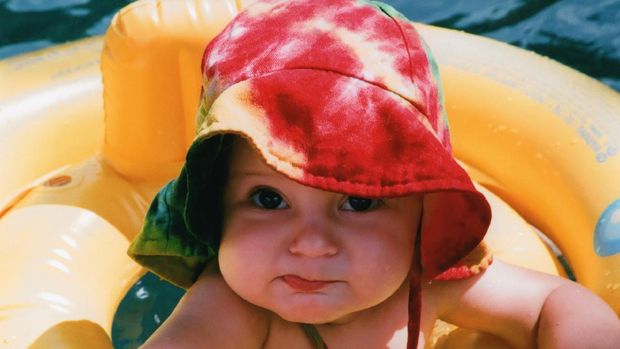 Baby playing in the sunshine on a hot summer day.