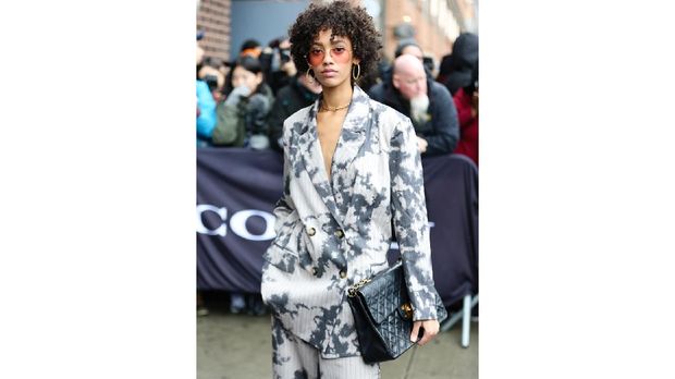 NEW YORK, NEW YORK - FEBRUARY 11: A guest is seen wearing a black and white tie dye print suit with a black purse and white sneakers outside of the Coach 1941 show during New York Fashion Week on February 11, 2020 in New York City.   Donell Woodson/Getty Images/AFP