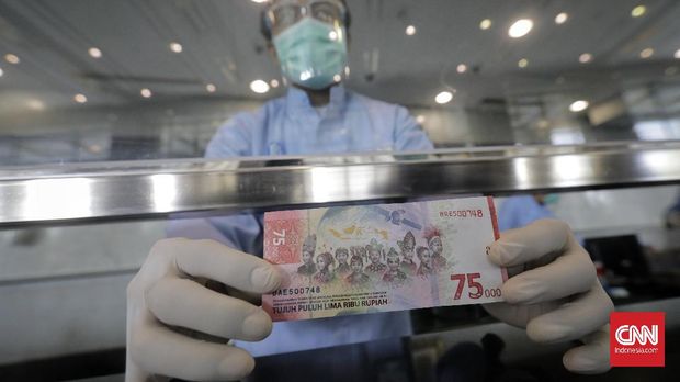 Warga memperlihatkan lembaran uang pecahan Rp 75 ribu sebelum serah terima di kantor pusat Bank Indonesia, Jakarta, Rabu, 19 Agustus 2020. Sehari sebelumnya Bank Indonesia dengan Kementerian Keuangan meluncurkan uang peringatan kemerdekaan 75 tahun RI pecahan Rp 75 ribu tersebut. CNN Indonesia/Adhi Wicaksono