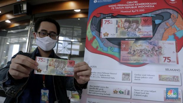 Warga menunjukkan uang baru 75.000 Ribu di Gedung BI. (CNBC Indonesia/Muhammad Sabki)