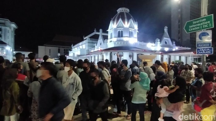 Ratusan pengunjung Alun-alun Suroboyo memenuhi pedestrian Jalan Gubernur Suryo hingga Yos Sudarso. Mereka tak bisa masuk alun-alun karena ada pembatasan pengunjung.