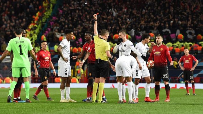 Italian referee Daniele Orsato (C) shows a red card to to Manchester Uniteds French midfielder Paul Pogba (centre L) during the first leg of the UEFA Champions League round of 16 football match between Manchester United and Paris Saint-Germain (PSG) at Old Trafford in Manchester, north-west England on February 12, 2019. (Photo by Paul ELLIS / AFP)