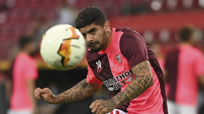 Sevillas Ever Banega takes a shot during the warm up ahead of the Europa League semifinal soccer match between Sevilla and Manchester United in Cologne, Germany, Sunday, Aug. 16, 2020. (Ina Fassbender/Pool Via AP)
