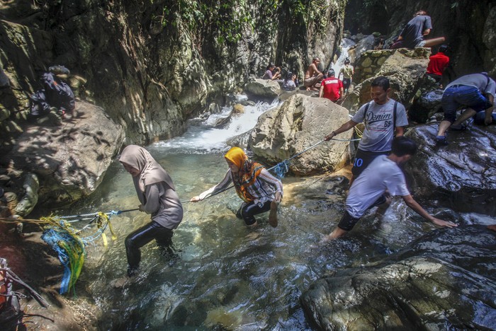 Sejumlah wisatawan menikmati air terjun Leuwi Hejo di Babakan Madang, Kabupaten Bogor, Jawa Barat, Jumat (21/8/2020). Wisata air terjun Leuwi Hejo menjadi salah satu tujuan wisata alam di Bogor pada libur Tahun Baru Islam 1 Muharam 1442 Hijriah dan libur akhir pekan. ANTARA FOTO/Yulius Satria Wijaya/pras.