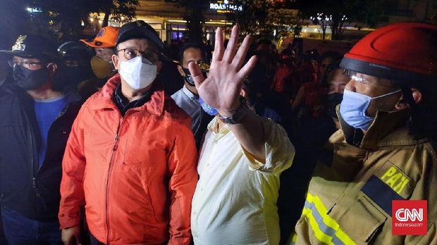 Gubernur DKI Jakarta Anies Baswedan meninjau langsung upaya pemadaman kebakaran gedung dikompleks Kejagung, Jakarta Selatan, Sabtu malam, 22 Agustus 2020. (CNNIndonesia/Thohirin)