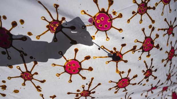 People with disabilities create batik, a wax-resist cloth dyeing technique indigenous to the region, with motifs depicting the COVID-19 coronavirus in Surabaya, East Java, on August 19, 2020. (Photo by JUNI KRISWANTO / AFP)