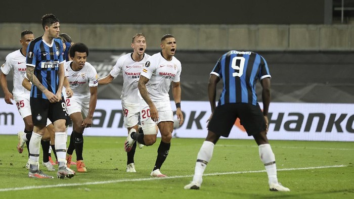 Sevillas Diego Carlos, second from right, celebrates after scoring his sides third goal as Inter Milans Romelu Lukaku, right, reacts during the Europa League final soccer match between Sevilla and Inter Milan in Cologne, Germany, Friday, Aug. 21, 2020. (Lars Baron, Pool Photo via AP)