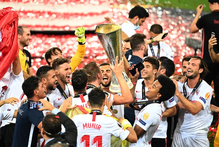 COLOGNE, GERMANY - AUGUST 21: Luuk de Jong, Joan Jordan, Jose Mena, Jules Kounde of Sevilla, and their teammates celebrate with the UEFA Europa League Trophy following their team's victory in the UEFA Europa League Final between Seville and FC Internazionale at RheinEnergieStadion on August 21, 2020 in Cologne, Germany. (Photo by Lars Baron/Getty Images)