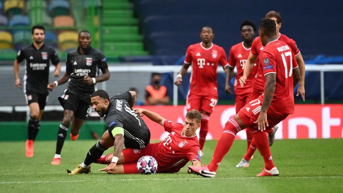 LISBON, PORTUGAL - AUGUST 19: Memphis Depay of Olympique Lyonnais is brought down by Joshua Kimmich of Bayern Munich during the UEFA Champions League Semi Final match between Olympique Lyonnais and Bayern Munich at Estadio Jose Alvalade on August 19, 2020 in Lisbon, Portugal. (Photo by Franck Fife/Pool via Getty Images)