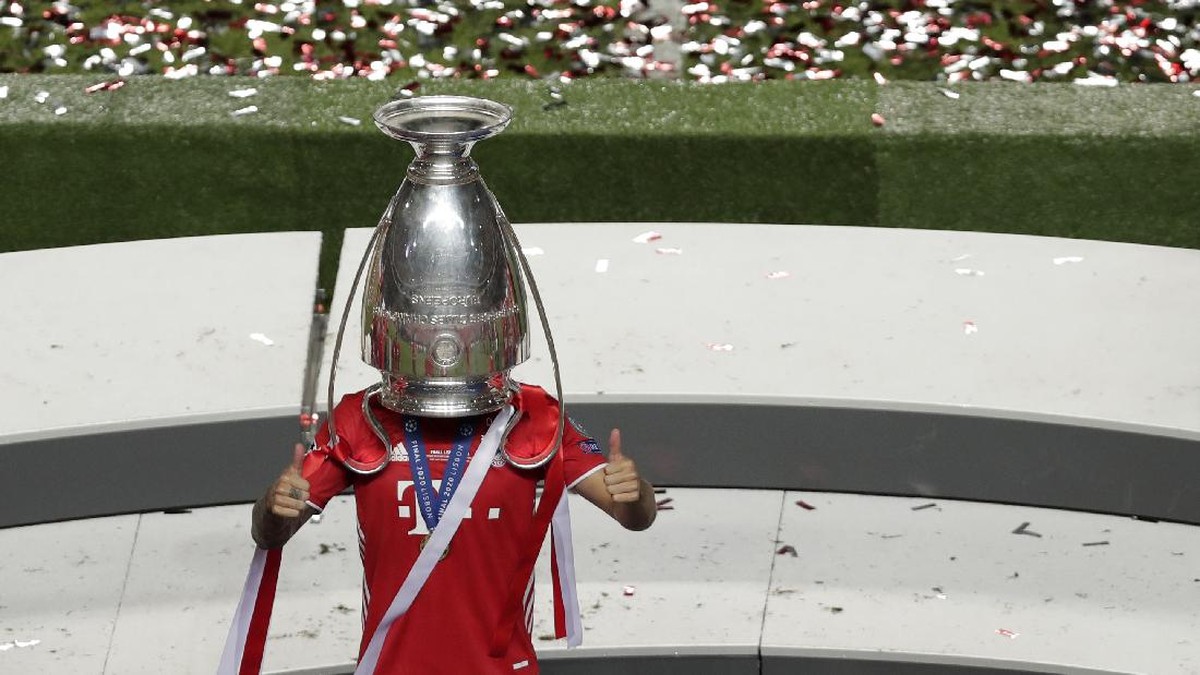 Lucas Hernandez memasukkan kepalanya ke trofi Liga Champions. (Foto: AP/Manu Fernandez)