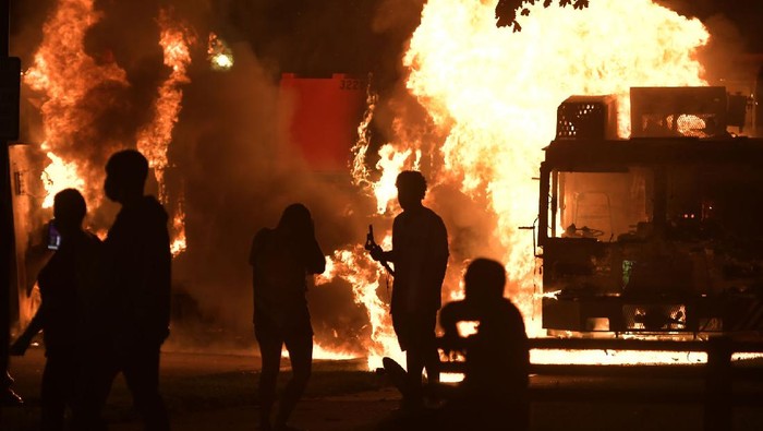 Garbage and dump trucks were set ablaze on Sunday, Aug. 23, 2020 by rioters near the Kenosha County Courthouse where they had been set up to prevent damage to the building. The building was still damaged and was closed on Monday. (Sean Krajacic/Kenosha News via AP)