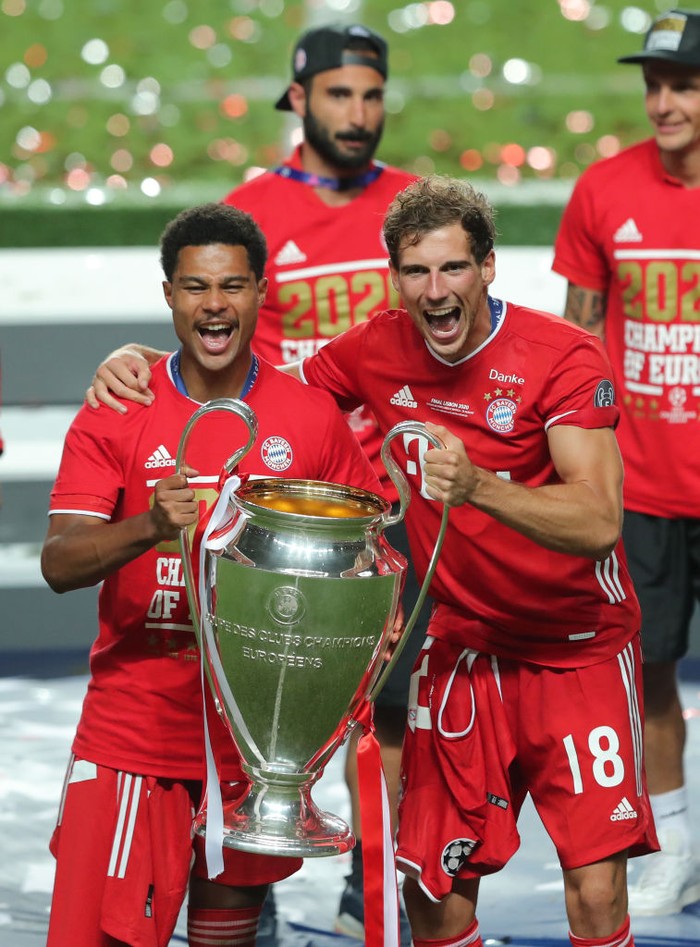 LISBON, PORTUGAL - AUGUST 23: Serge Gnabry of FC Bayern Munich and team mate Leon Goretzka celebrate with the Champions League Trophy following their team's victory in the UEFA Champions League Final match between Paris Saint-Germain and Bayern Munich at Estadio do Sport Lisboa e Benfica on August 23, 2020 in Lisbon, Portugal. (Photo by Miguel A. Lopes/Pool via Getty Images)