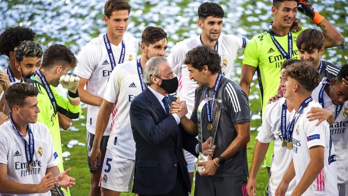 Real Madrids team players with Real Madrid president Florentino Perez, centre left and Real Madrids head coach Raul Gonzalez Blanco,celebrate with the trophy after winning the UEFA Youth League final soccer match between SL Benfica from Portugal and Real Madrid CF from Spain at the Colovray Sports Centre stadium in Nyon, Switzerland, Tuesday, Aug. 25, 2020. (Jean-Christophe Bott/Keystone via AP)