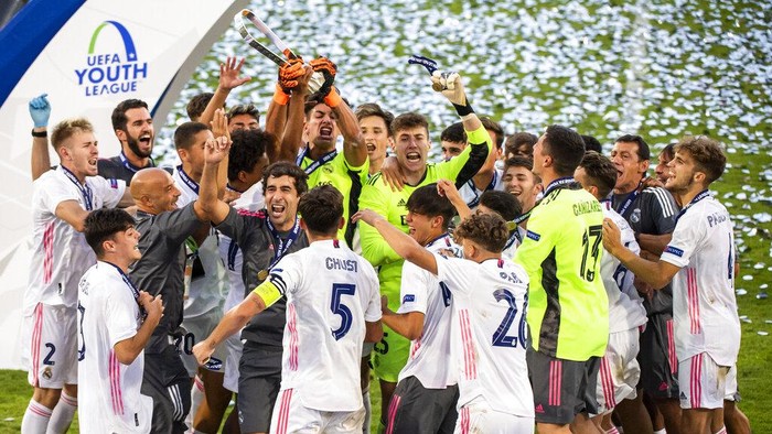 Real Madrids team players and staff celebrate with the trophy after winning the UEFA Youth League final soccer match between SL Benfica from Portugal and Real Madrid CF from Spain at the Colovray Sports Centre stadium in Nyon, Switzerland, Tuesday, Aug. 25, 2020. (Jean-Christophe Bott/Keystone via AP)