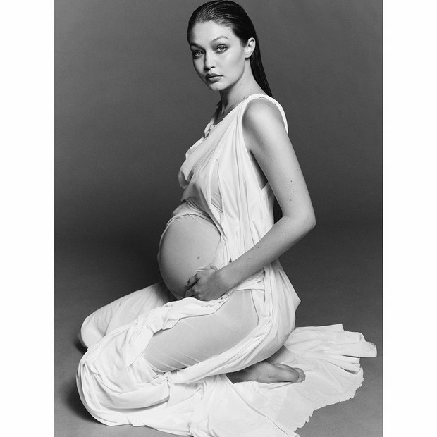 Dalam foto maternity, Gigi Hadid itu tampil cantik serta glamour dalam balutan gaun panjang putih transparan.