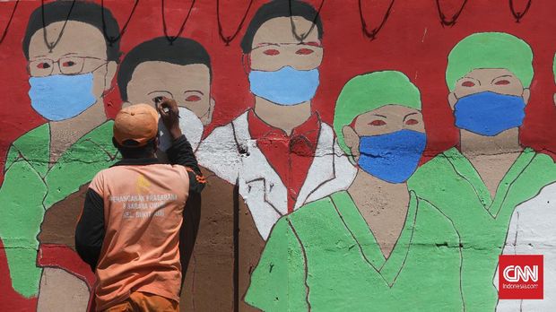 Bukit Duri PPSU officers finish making a mural containing a message to alert about the spread of the Corona virus in the Bukit Duri area, Jakarta, on Thursday August 27, 2020. The implementation of large-scale social restrictions (PSBB ) in transition in DKI Jakarta from August 14, 2020 will end on Thursday (8/27)).  CNN Indonesia / Safir Makki