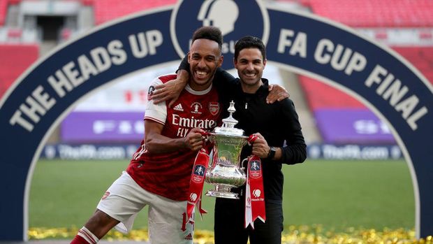 LONDON, ENGLAND - AUGUST 01: Pierre-Emerick Aubameyang of Arsenal poses with Mikel Arteta, Manager of Arsenal and the FA Cup Trophy after their teams victory in the Heads Up FA Cup Final match between Arsenal and Chelsea at Wembley Stadium on August 01, 2020 in London, England. Football Stadiums around Europe remain empty due to the Coronavirus Pandemic as Government social distancing laws prohibit fans inside venues resulting in all fixtures being played behind closed doors. (Photo by Catherine Ivill/Getty Images)