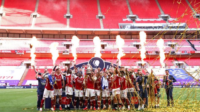 LONDON, ENGLAND - AUGUST 01:  Pierre-Emerick Aubameyang of Arsenal lifts the FA Cup Trophy with his team mates after their victory in during the FA Cup Final match between Arsenal and Chelsea at Wembley Stadium on August 01, 2020 in London, England. Football Stadiums around Europe remain empty due to the Coronavirus Pandemic as Government social distancing laws prohibit fans inside venues resulting in all fixtures being played behind closed doors. (Photo by Catherine Ivill/Getty Images)