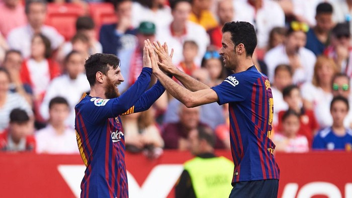 SEVILLE, SPAIN - FEBRUARY 23: Lionel Messi of FC Barcelona celebrates with his teammates Sergio Busquets of FC Barcelona after scoring his teams third goal during the La Liga match between Sevilla FC and FC Barcelona at Estadio Ramon Sanchez Pizjuan on February 23, 2019 in Seville, Spain. (Photo by Aitor Alcalde/Getty Images)
