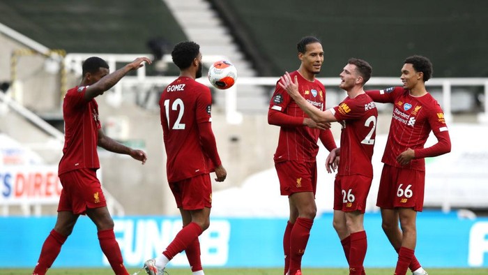NEWCASTLE UPON TYNE, ENGLAND - JULY 26: Joe Gomez, Virgil van Dijk, Andy Robertson and Trent Alexander-Arnold of Liverpool celebrate after the Premier League match between Newcastle United and Liverpool FC at St. James Park on July 26, 2020 in Newcastle upon Tyne, England. Football Stadiums around Europe remain empty due to the Coronavirus Pandemic as Government social distancing laws prohibit fans inside venues resulting in all fixtures being played behind closed doors. (Photo by Owen Humphreys/Pool via Getty Images)
