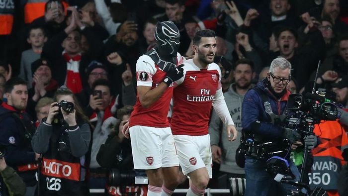 Pierre Aubameyang LONDON, ENGLAND - MARCH 14: Pierre-Emerick Aubameyang of Arsenal dons a Black Panther mask as he celebrates after scoring his teams third goal with Sead Kolasinac of Arsenal during the UEFA Europa League Round of 16 Second Leg match between Arsenal and Stade Rennais at Emirates Stadium on March 14, 2019 in London, England. (Photo by Alex Morton/Getty Images)