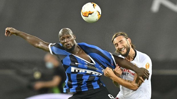 Inter Milan's Romelu Lukaku, left, and Sevilla's Nemanja Gudelj fight for the ball during the Europa League final soccer match between Sevilla and Inter Milan at the Rhein Energie Stadium in Cologne, Germany, Friday, Aug. 21, 2020. (AP Photo/Martin Meissner, Pool)