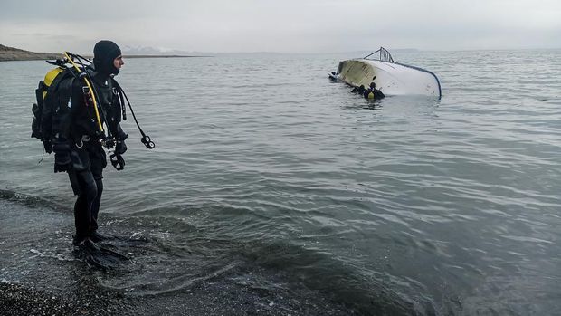 (FILES) In this file photo taken on December 26, 2019, a rescue diver stands on the shores of Lake Van after a boat carrying refugees and migrants sank in eastern Turkey as seven migrants were killed after their boat sank in Lake Van in eastern Turkey. - Europe in  2015 suffered its worst refugee crisis since World War II, when over one million people fled to the continent. (Photo by - / DHA / AFP) / Turkey OUT
