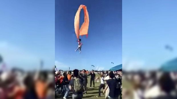 In this image made from video, a 3 year old girl is lifted into the air by a large kite during a kite festival in Hsinchu, northern Taiwan, Sunday, Aug. 30, 2020. The wind slowed down and the girl was safely recovered by adults on the ground. (Credit: Dainese Hsu)