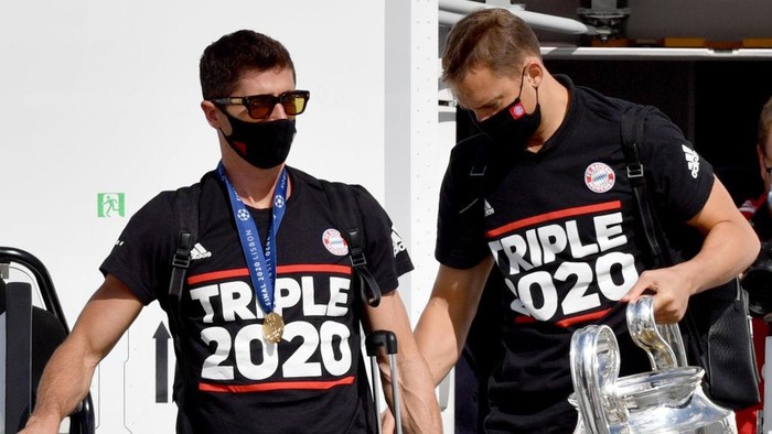 MUNICH, GERMANY - AUGUST 24: Robert Lewandowski (L) and Manuel Neuer of FC Bayern Muenchen disembark the airplane with the trophy as UEFA Champions League winners FC Bayern Munich arrive at Airport Munich on August 24, 2020 in Munich, Germany. (Photo by Philipp Guelland - Pool/Getty Images)