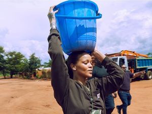 Potret Rihanna saat Aksi Sosial, Tanpa Makeup Glamor dan Bawa Ember di Kepala