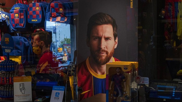 A poster with the face of Barcelona soccer player Lionel Messi is displayed at a F.C. Barcelona store in Barcelona, Spain on Tuesday, Sept. 1, 2020. Barcelona is banking on a face-to-face meeting with Lionel Messi to try to convince him to stay. Talks with Messi’s father-agent are expected this week in Barcelona but the club also hopes to sit down with the player himself.(AP Photo/Emilio Morenatti)