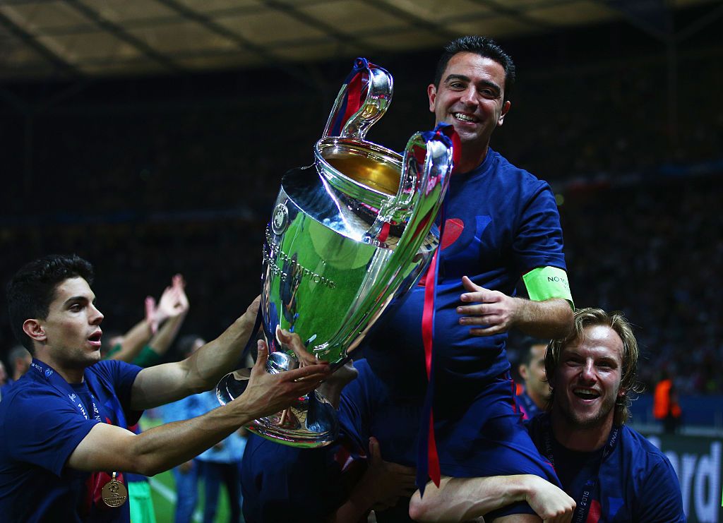 BERLIN, GERMANY - JUNE 06: Xavi Hernandez of Barcelona celebrates with Ivan Rakitic (R) and the trophy after the UEFA Champions League Final between Juventus and FC Barcelona at Olympiastadion on June 6, 2015 in Berlin, Germany. (Photo by Paul Gilham/Getty Images)