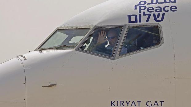 The captain of the El Al airliner which will carry US and Israeli delegations to the United Arab Emirates waves to spectators as the plane prepares to take off on the first-ever commercial flight from Israel to the UAE, at Ben Gurion Airport near Tel Aviv, Israel, Monday, Aug. 31, 2020. (Menahem Kahana/Pool via AP)