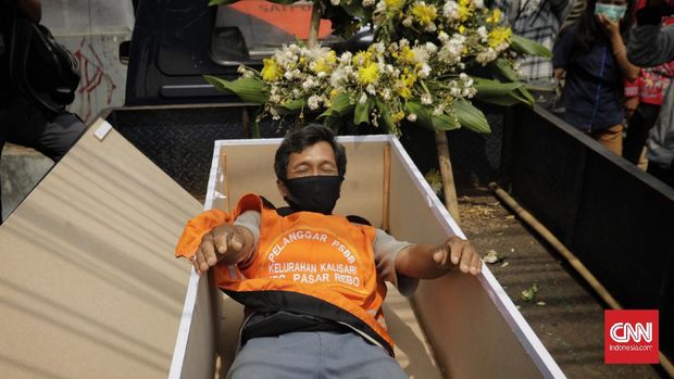 Warga diberikan hukuman masuk dalam peti mati saat melanggar protokol kesehatan di Kawasan Kalisari, Pasar Rebo, Jakarta. Kamis, 3 September 2020 Bagi warga yang melanggar protokol kesehatan covid-19 diberikan pilihan hukuman  berupa denda Rp.250 ribu, bersih-bersih lingkungan atau masuk peti mati selama 1 menit, dengan tujuan menimbulkan efek jera.