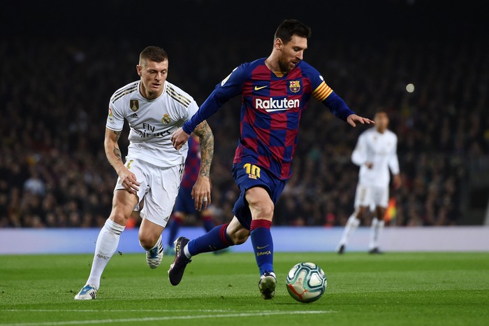 Lionel Messi, Toni Kroos BARCELONA, SPAIN - DECEMBER 18: Lionel Messi of Barcelona holds off Toni Kroos of Real Madrid during the Liga match between FC Barcelona and Real Madrid CF at Camp Nou on December 18, 2019 in Barcelona, Spain. (Photo by Alex Caparros/Getty Images)