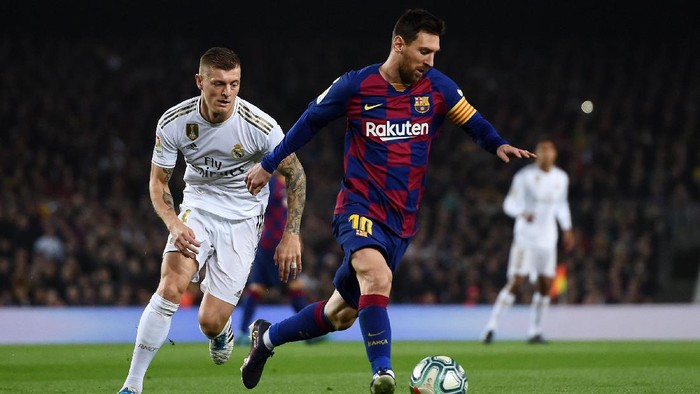 BARCELONA, SPAIN - DECEMBER 18:  Lionel Messi of Barcelona holds off Toni Kroos of Real Madrid during the Liga match between FC Barcelona and Real Madrid CF at Camp Nou on December 18, 2019 in Barcelona, Spain. (Photo by Alex Caparros/Getty Images)