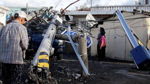 People look at an electric pole downed by Typhoon Maysak in the southeastern port city of Ulsan on September 3, 2020. - At least one person was killed and more than 2,000 people evacuated to temporary shelters in South Korea as a powerful typhoon churned across the peninsula, authorities said on September 3. (Photo by - / YONHAP / AFP) / - South Korea OUT / REPUBLIC OF KOREA OUT  NO ARCHIVES  RESTRICTED TO SUBSCRIPTION USE