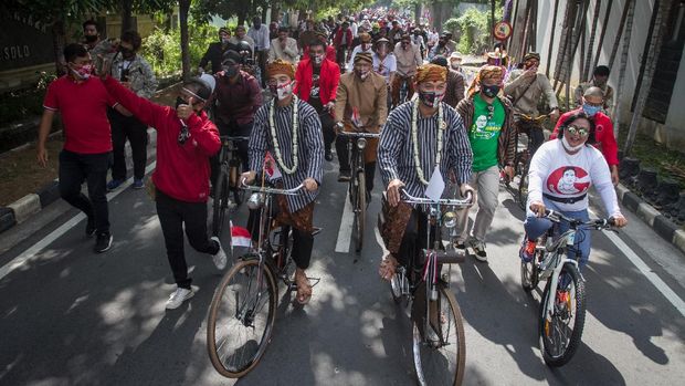 Pasangan bakal calon Wali Kota dan Wakil Wali Kota Solo Gibran Rakabuming Raka (kelima kiri) dan Teguh Prakosa (kelima kanan) menaiki sepeda ontel menuju kantor KPU Solo untuk melakukan pendaftaran Pemilihan Wali Kota (Pilwakot) 2020 di Solo, Jawa Tengah, Jumat (4/9/2020). Gibran Rakabuming Raka dan Teguh Prakosa yang diusung PDI Perjuangan resmi mendaftarkan diri ke KPU Kota Solo sebagai pasangan bakal calon Wali Kota dan Wakil Wali Kota pada Pilkada 2020 mendatang. ANTARA FOTO/Mohammad Ayudha/wsj.