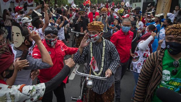 Pasangan bakal calon Wali Kota dan Wakil Wali Kota Solo Gibran Rakabuming Raka (kelima kiri) dan Teguh Prakosa (kelima kanan) menaiki sepeda ontel menuju kantor KPU Solo untuk melakukan pendaftaran Pemilihan Wali Kota (Pilwakot) 2020 di Solo, Jawa Tengah, Jumat (4/9/2020). Gibran Rakabuming Raka dan Teguh Prakosa yang diusung PDI Perjuangan resmi mendaftarkan diri ke KPU Kota Solo sebagai pasangan bakal calon Wali Kota dan Wakil Wali Kota pada Pilkada 2020 mendatang. ANTARA FOTO/Mohammad Ayudha/wsj.