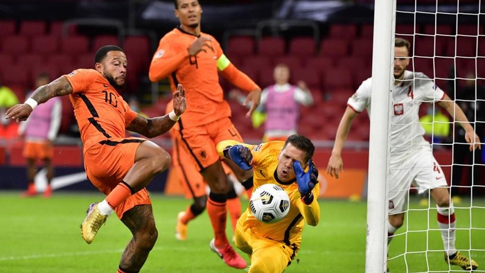 Polands goal keeper Bartlomiej Dragowski (R) stops the ball in front of Dutchs forward Memphis Depay (L) during the UEFA Nations League football match between Netherlands and Poland at the Johan Cruijff Arena stadium, in Amsterdam, on September 4, 2020. (Photo by JOHN THYS / AFP)