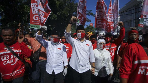 Pasangan bakal calon Wali Kota dan Wakil Wali Kota Surabaya, Eri Cahyadi (tengah) dan Armuji (kedua kiri) berjalan menuju kantor KPU Surabaya untuk pendaftaran calon kepala daerah di Surabaya, Jawa Timur, Jumat (4/9/2020). Pasangan Eri Cahyadi dan Armuji maju pada bursa Pilkada Surabaya 2020 diusung PDI Perjuangan, PSI serta enam partai nonparlemen yakni Partai Hanura, PBB, Partai Berkarya, Partai Garuda, PKPI dan Perindo. ANTARA FOTO/Moch Asim/wsj.