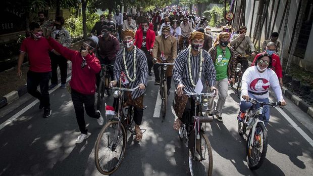 Konvoi Daftar Pilkada Serentak di Tengah Pandemi Pasangan bakal calon Wali Kota dan Wakil Wali Kota Solo Gibran Rakabuming Raka (kelima kiri) dan Teguh Prakosa (kelima kanan) menaiki sepeda ontel menuju kantor KPU Solo untuk melakukan pendaftaran Pemilihan Wali Kota (Pilwakot) 2020 di Solo, Jawa Tengah, Jumat (4/9/2020). Gibran Rakabuming Raka dan Teguh Prakosa yang diusung PDI Perjuangan resmi mendaftarkan diri ke KPU Kota Solo sebagai pasangan bakal calon Wali Kota dan Wakil Wali Kota pada Pilkada 2020 mendatang. ANTARA FOTO/Mohammad Ayudha/wsj.