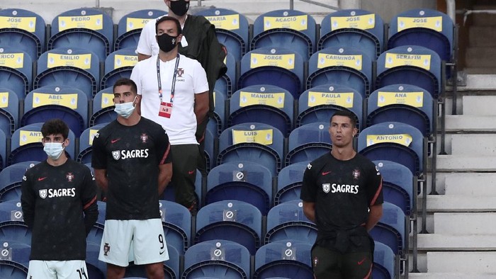 Portugals Cristiano Ronaldo, right, stands next to the team substitutes on the stands during the UEFA Nations League soccer match between Portugal and Croatia at the Dragao stadium in Porto, Portugal, Saturday, Sept. 5, 2020. Ronaldo is not playing due to an injury. (AP Photo/Miguel Angelo Pereira)