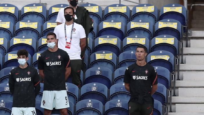 Portugal Kroasia Nations League Soccer Portugals Cristiano Ronaldo, right, stands next to the team substitutes on the stands during the UEFA Nations League soccer match between Portugal and Croatia at the Dragao stadium in Porto, Portugal, Saturday, Sept. 5, 2020. Ronaldo is not playing due to an injury. (AP Photo/Miguel Angelo Pereira)