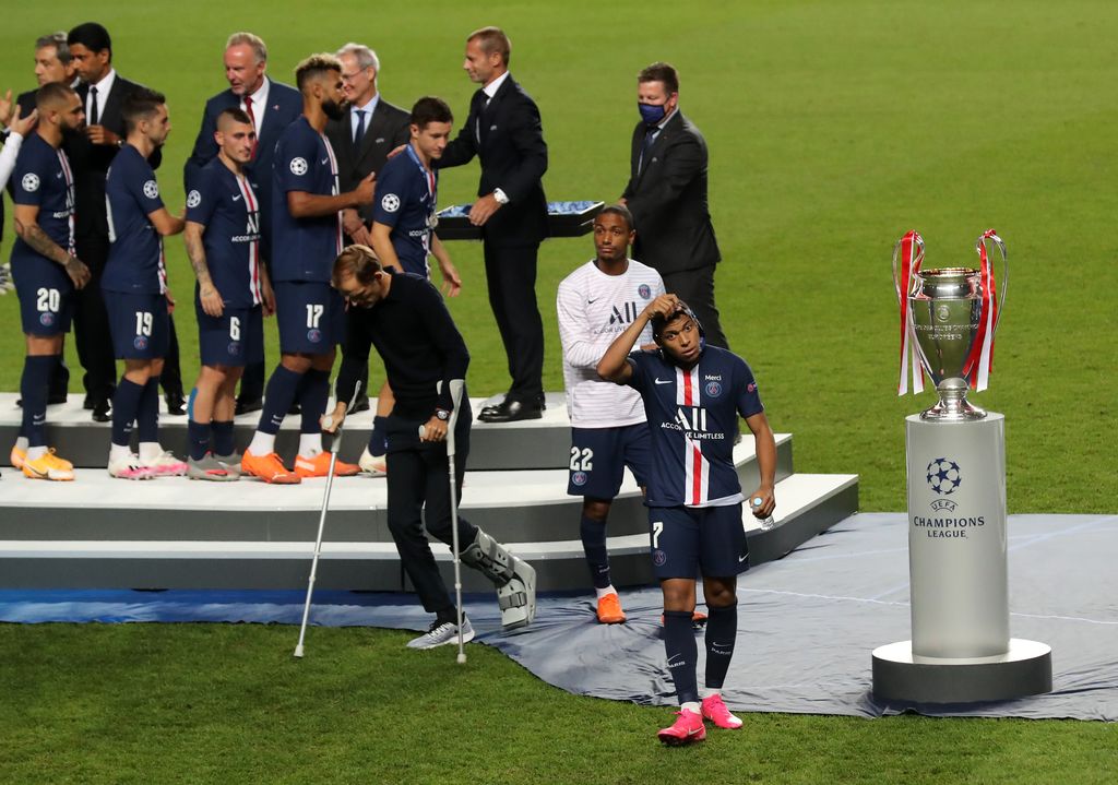 LISBON, PORTUGAL - AUGUST 23: Kylian Mbappe of Paris Saint-Germain removes his runners up medal as he walks past the UEFA Champions League Trophy following his team's defeat in the UEFA Champions League Final match between Paris Saint-Germain and Bayern Munich at Estadio do Sport Lisboa e Benfica on August 23, 2020 in Lisbon, Portugal. (Photo by Miguel A. Lopes/Pool via Getty Images)