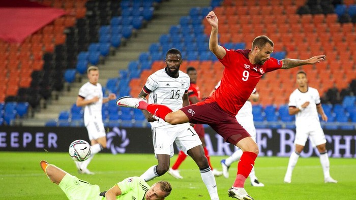 Germanys Bernd Leno makes a save from Switzerlands Haris Seferovic, right, with Germanys Antonio Ruediger, centre, in action during the UEFA Nations League group 4 soccer match between Switzerland and Germany at the St. Jakob-Park stadium in Basel, Switzerland, on Sunday, Sept. 6, 2020. (Peter Klaunzer/Keystone via AP)