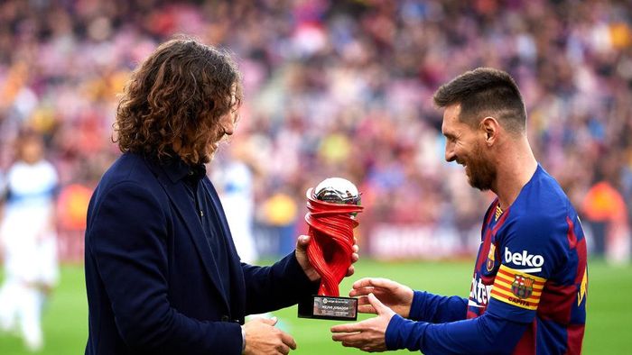 Carles Puyol BARCELONA, SPAIN - DECEMBER 21: Lionel Messi of FC Barcelona receives the trophy as best player of November in the Spanish La Liga from Carles Puyol before the La Liga match between FC Barcelona and Deportivo Alaves at Camp Nou on December 21, 2019 in Barcelona, Spain. (Photo by Alex Caparros/Getty Images)