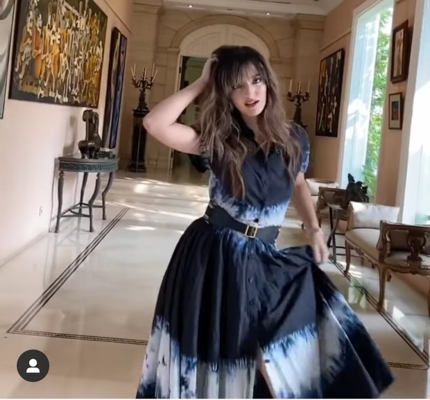 Nia juga memakai koleksi mid dress shibori warna navy blue yang dipadukan dengan sepatu boots tinggi hitam.