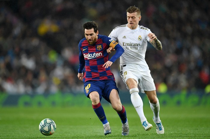 MADRID, SPAIN - MARCH 01: Lionel Messi of FC Barcelona battles for possession with Toni Kroos of Real Madrid during the Liga match between Real Madrid CF and FC Barcelona at Estadio Santiago Bernabeu on March 01, 2020 in Madrid, Spain. (Photo by David Ramos/Getty Images)